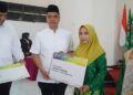 Alhamdulillah! Ribuan Guru Non-ASN di Jepara Terima Kartu Guru Sejahtera 35 Bupati Jepara, Witiarso Utomo, memberikan Kartu Guru Sejahtera secara simbolis kepada salah satu guru non-ASN dalam acara halal bihalal dan Harlah ke-74 Pergunu di Aula Sunu Ngesti Tomo, Kabupaten Jepara, Sabtu, 11 April 2026. (Tomi Budianto/Lingkarjateng.id)