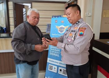 Baur STNK Satlantas Polres Batang, Aipda Muhammad Azizi saat menunjukkan aplikasi Signal ke warga. Foto : Dok. Satlantas Polres Batang for Lingkar