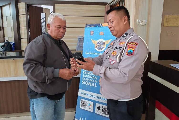 Tak Perlu Antre Bayar Pajak Tahunan Kendaraan di Samsat Batang, Kini Warga Cukup Lewat Aplikasi Signal 25 Baur STNK Satlantas Polres Batang, Aipda Muhammad Azizi saat menunjukkan aplikasi Signal ke warga. Foto : Dok. Satlantas Polres Batang for Lingkar