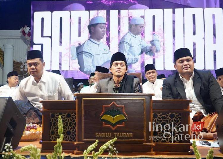 Puncak HUT Jepara, Ribuan Jemaah Hadiri Pengajian Akbar Bersama Gus Iqdam 25 Gus Iqdam duduk diantara Bupati Jepara Witiarso Utomo dengan Wakil Bupati Muhammad Ibnu Hajar dalam acara pengajian akbar puncak HUT ke-477 Jepara di Alun-alun 1 Jepara pada Selasa, 14 April 2026 malam. (Tomi Budianto/Lingkarjateng.id)