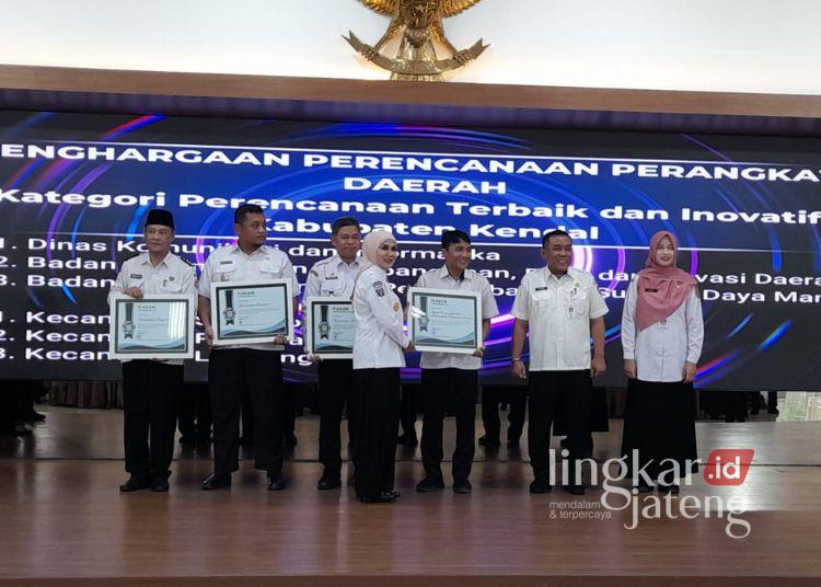 Musrenbang RKPD 2027 Kendal Tekankan Penguatan Birokrasi Adaptif 25 Kepala Dinas Kominfo, Ardhi Prasetiyo saat menerima penghargaan dari Bupati Kendal, Dyah Kartika Permanasari sebagai Perangkat Daerah dengan perencanaan terbaik dan inovatif. (Anik Kustiani/Lingkarjateng.id)