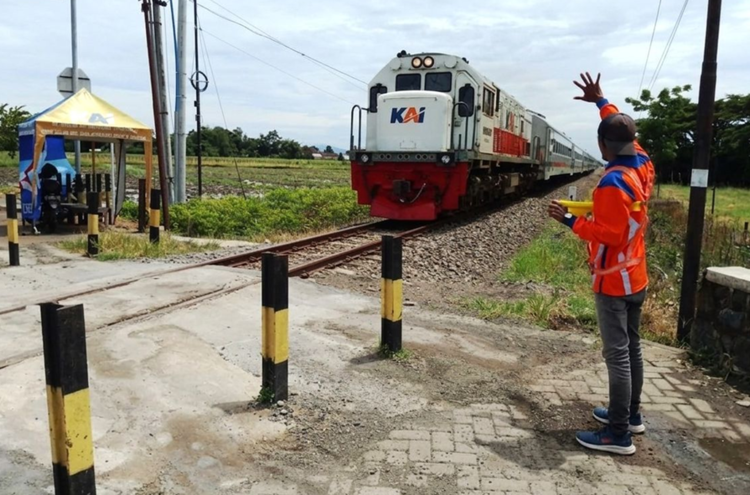 Petugas penjaga di salah satu perlintasan sebidang kereta api. Foto : Dok. KAI