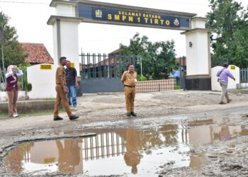 Plt. Bupati Pekalongan, Sukirman, meninjau jalan rusak di depan SMPN 1 Tirto, Kecamatan Tirto, Kabupaten Pekalongan, Senin, 4 Mei 2026. (Fahri Akbar/Lingkarjateng.id)