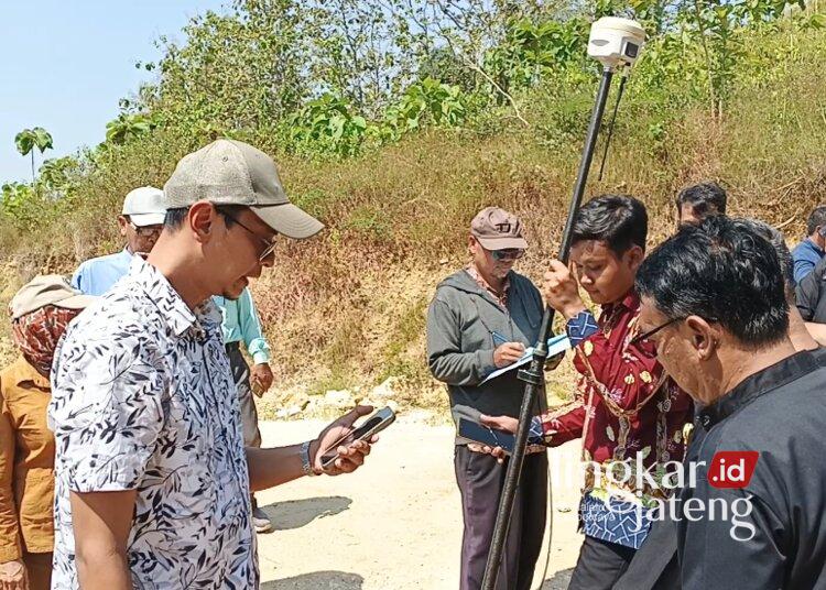 Petugas BPN Blora melakukan pengukuran dan penentuan titik koordinat batas lahan yang disengketakan di Desa Sendangharjo, Kecamatan Blora Kota, Kamis, 11 Juni 2026. (Eko Wicaksono/Lingkarjateng.id)