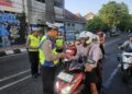 Anggota Polres Kudus saat melaksanakan sosialisasi terkait Operasi Patuh Candi 2026 di kawasan Simpang Tujuh Kudus, Jumat (5/6). Foto: Nisa Hafizhotus Syarifa/Lingkar