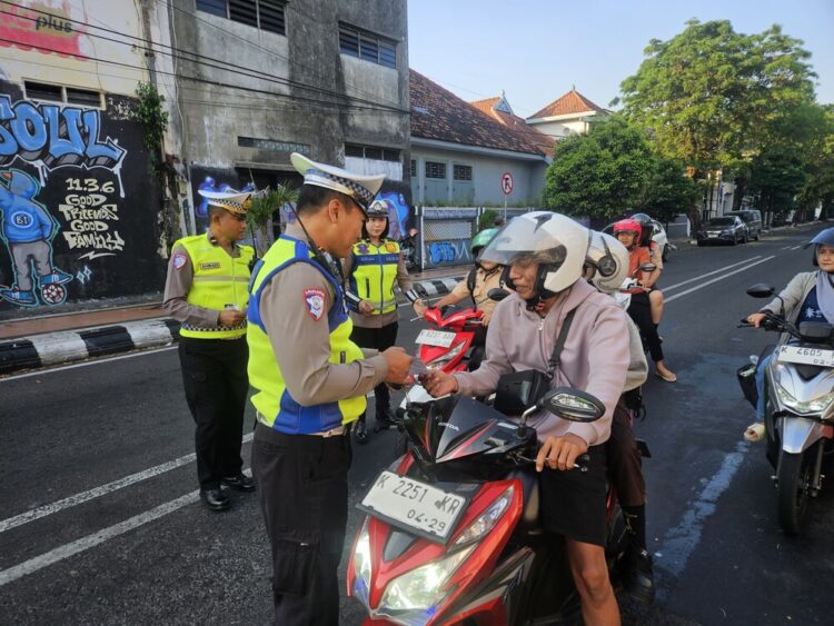 Anggota Polres Kudus saat melaksanakan sosialisasi terkait Operasi Patuh Candi 2026 di kawasan Simpang Tujuh Kudus, Jumat (5/6). Foto: Nisa Hafizhotus Syarifa/Lingkar