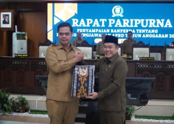 Bupati Jepara, Witiarso Utomo, menyerahkan dokumen Rancangan Peraturan Daerah (Ranperda) Pertanggungjawaban Pelaksanaan APBD Tahun Anggaran 2025 kepada Ketua DPRD Jepara, Agus Sutisna, dalam rapat paripurna, Senin, 22 Juni 2026. (Tomi Budianto/Lingkarjateng.id)