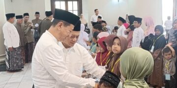 Bupati Kudus, Sam'ani Intakoris, memberi santunan kepada anak yatim di Masjid Agung Kudus, Kamis, 25 Juni 2026. (Ahmad Abror/Lingkarjateng.id)