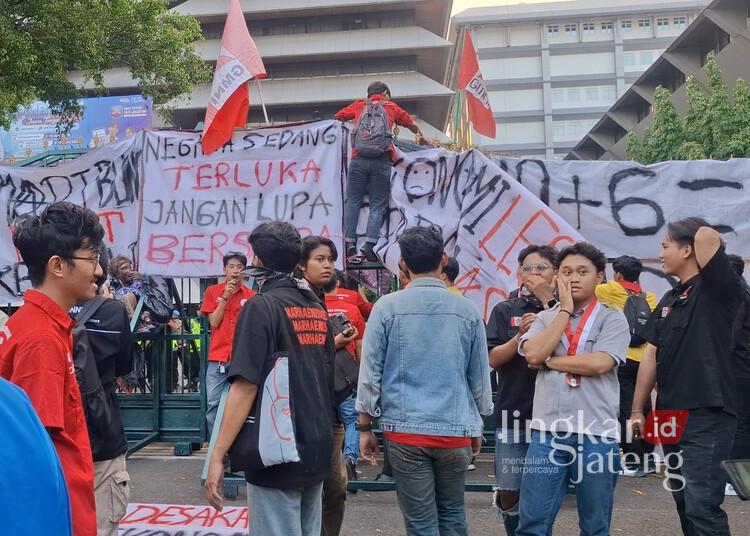 Ribuan Mahasiswa Semarang Demo di Depan Kantor Gubernur Jateng, Ini Tuntutannya 25 Aliansi BEM Semarang Raya membentangkan spanduk tuntutan saat menggelar aksi demonstrasi di depan Kantor Gubernur Jawa Tengah, Semarang, pada Senin, 15 Juni 2026. (Syahril Muadz/Lingkarjateng.id)