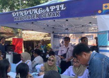 Warga antri memanfaatkan pelayanan adminduk yang dibuka oleh Dindukcapil Demak dalam kegiatan Demang Ngantor Deso, di Balai desa Mangunrejo, Kebonagung. Foto : Burhan Aslam/Lingkar