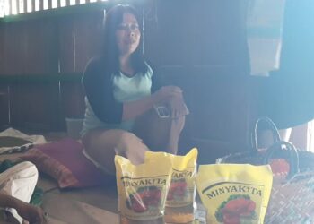 Warga Desa Penadaran, Kecamatan Gubug, Kabupaten Grobogan, menunjukkan Minyakita bantuan pangan yang berbau solar, Senin, 29 Juni 2026. (Ahmad Abror/Lingkarjateng.id)