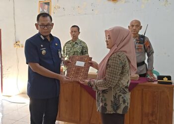 Camat Bojong, Farid Abdul Khakim, menyerahkan surat keputusan (SK) pemberhentian sementara Kepala Desa Randumuktiwaren kepada Sekretaris Desa di Balai Desa Randumuktiwaren, Kecamatan Bojong, Kabupaten Pekalongan, Jumat, 5 Juni 2026. (Fahri Akbar/Lingkarjateng.id)