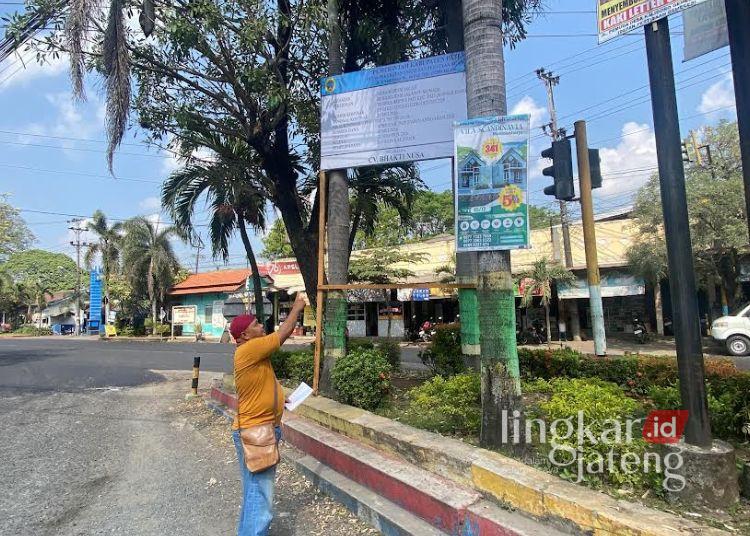Koordinator Germap, Yayak Gundul mengecek papan proyek rehabilitasi Jalan H. Munadi atau depan kawasan Terminal Kembangjoyo hingga SMP Negeri 6 Pati, Senin, 15 Juni 2026.  (Fahtur Rohman/Lingkarjateng.id)