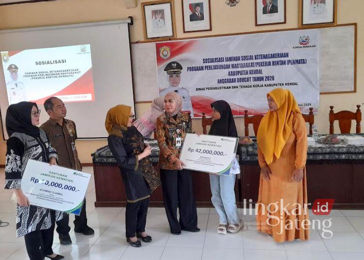 Bupati Kendal, Dyah Kartika Permanasari (ketiga kanan) menyerahkan secara simbolis jaminan perlindungan sosial pekerja rentan dari anggaran DBHCHT di Aula Kecamatan Kangkung, Kabupaten Kendal pada Selasa, 7 Juli 2026. (Anik Kustiani/Lingkarjateng.id)