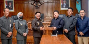 Wali Kota Salatiga Robby Hernawan (ketiga kiri) menyerahkan Rancangan Peraturan Daerah tentang Pertanggungjawaban Pelaksanaan APBD Tahun Anggaran 2025 kepada Ketua DPRD Dance Ishak Palit (ketiga kanan) saat sidang paripurna di Kantor DPRD, Senin, 13 Juli 2026. (Dok Prokompim Setda Salatiga/Lingkarjateng.id)