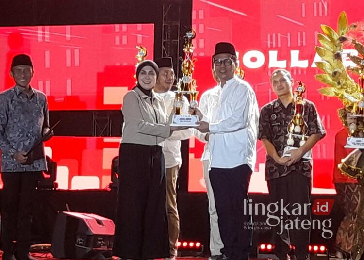 Bupati Kendal, Dyah Kartika Permanasari, menyerahkan piala kepada pemenang lomba stand saat penutupan Kendal Open Fair 2026 di Stadion Utama Kebondalem, Senin malam, 27 Juli 2026. (Anik Kustiani/Lingkarjateng.id)