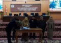 Bupati Demak, Eisti'anah, menandatangani pengesahan empat Perda di hadapan pimpinan DPRD Demak dalam rapat paripurna di gedung dewan setempat, Selasa, 28 Juli 2026. (M. Burhanuddin Aslam/Lingkarjateng.id)
