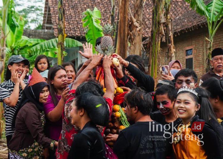Sejumlah warga berebut hasil bumi yang ditempatkan di gunungan saat prosesi Merti Dusun RW 05 Sugihwaras, Kelurahan Randuacir, Kecamatan Argomulyo, Kota Salatiga pada Selasa, 28 Juli 2026. (Prokompim Setda Salatiga/Lingkarjateng.id)