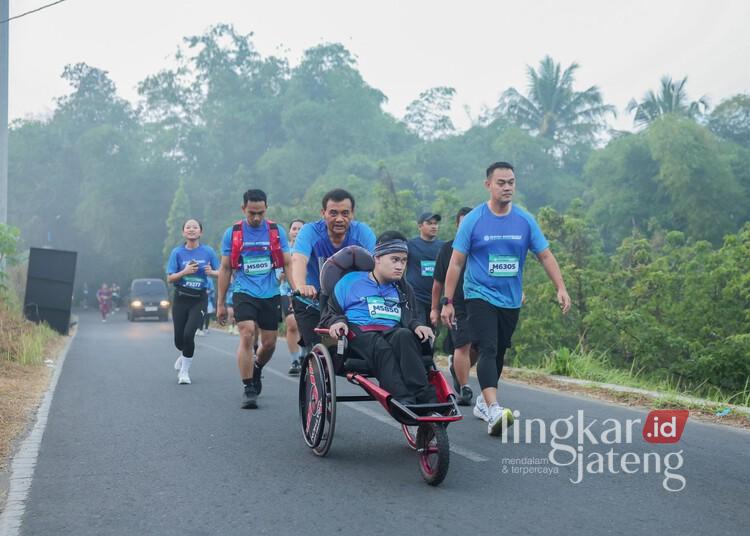 Ikuti Rupiah Borobudur Playon 2026, Gubernur Jateng Dorong Sport Tourism Digenjot 25 Gubernur Jawa Tengah, Ahmad Luthfi, mendorong kursi roda putranya mengikuti gelaran Rupiah Borobudur Playon 2026 di kawasan Candi Borobudur, Kabupaten Magelang, Minggu, 5 Juli 2026. (Humas Pemprov Jateng/Lingkarjateng.id)