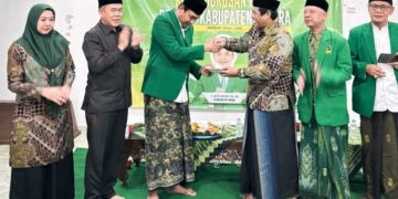Ketua DPC PPP Jepara, Haizul Ma'arif, menerima tumpeng dalam acara doa bersama di Sekretariat DPC PPP Jepara, Rabu, 22 Juli 2026. (Tomi Budianto/Lingkarjateng.id)