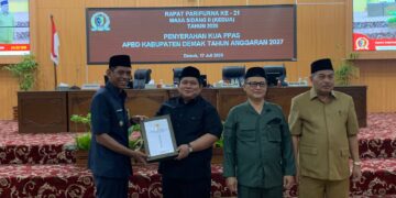 Wakil Bupati Demak Muhammad Badruddin mewakili Bupati Demak Eisti’anah menyerahkan Rancangan KUA dan PPAS APBD Kabupaten Demak Tahun 2027 kepada Ketua DPRD Demak, Zayinul Fata, dalam rapat paripurna, Jumat (17/7). Foto: Burhan/Lingkar