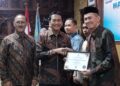 Wabup Batang Suyono (tengah) menyerahkan piagam penghargaan ke salah satu pengurus koperasi dalam peringatan Hari Koperasi ke-79 di Aula Kantor Bupati Batang, Jumat (24/7/2026). Foto : Diskominfo Batang/Lingkar