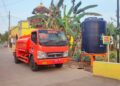 Petugas BPBD Kabupaten Pekalongan mengisi tandon air menggunakan truk tangki guna mendistribusikan kebutuhan air bersih di wilayah Kecamatan Siwalan, Minggu, 26 Juli 2026. (Fahri Akbar/Lingkarjateng.id)