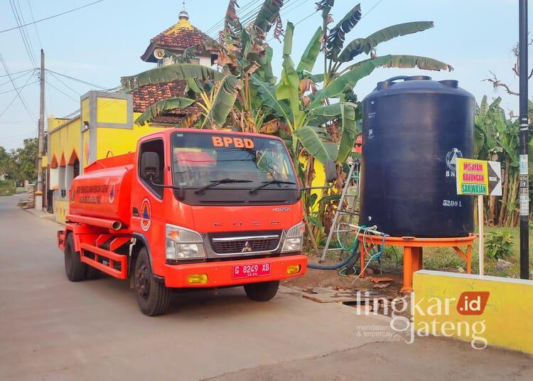 Petugas BPBD Kabupaten Pekalongan mengisi tandon air menggunakan truk tangki guna mendistribusikan kebutuhan air bersih di wilayah Kecamatan Siwalan, Minggu, 26 Juli 2026. (Fahri Akbar/Lingkarjateng.id)