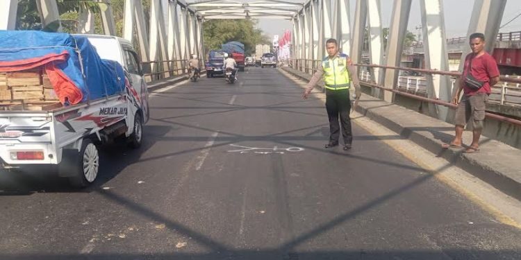 TKP: Polisi menunjukkan lokasi kecelakaan lalu lintas di Jalan Raya Kudus–Demak atau di kawasan Jembatan Tanggulangin pada Selasa, 28 Juli 2026 sekitar sekitar pukul 06.15 WIB. (Burhanuddin Aslam/Lingkarjateng.id)