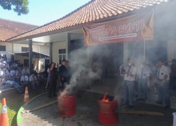 Sejumlah siswa SMA Kristen Satya Wacana menyaksikan pemusnahan barang bukti perkara pidana dengan cara Dibakar pada Senin, 20 Juli 2026. (Angga Rosa/Lingkarjateng.id)