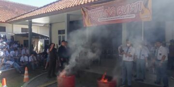 Sejumlah siswa SMA Kristen Satya Wacana menyaksikan pemusnahan barang bukti perkara pidana dengan cara Dibakar pada Senin, 20 Juli 2026. (Angga Rosa/Lingkarjateng.id)