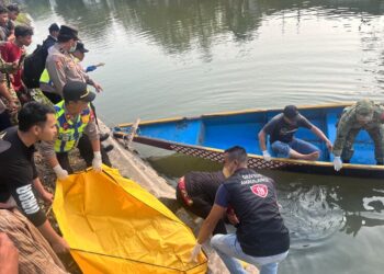 Personel Polsek Demak mengevakuasi mayat pria yang ditemukan mengambang di Sungai Kalijajar, kawasan Betengan, Kelurahan Bintoro, Kecamatan Demak Kota, Kabupaten Demak, Jumat, 31 Juli 2026. (M. Burhanuddin Aslam/Lingkarjateng.id)