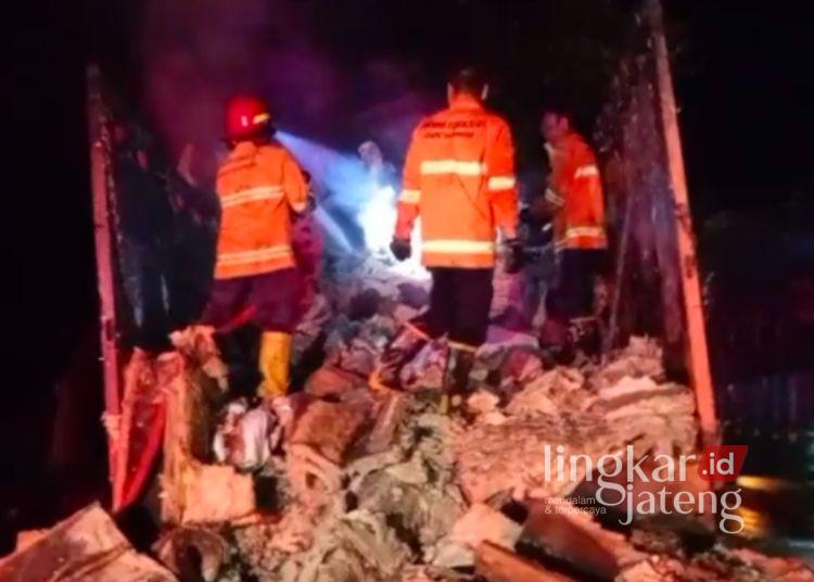 Petugas pemadam kebakaran menjinakkan api yang membakar truk pengangkut glasswool di Pantura Rembang pada Senin, 6 Juli 2026 malam sekitar pukul 21.00 WIB. (Dok. Pribadi/Lingkarjateng.id)