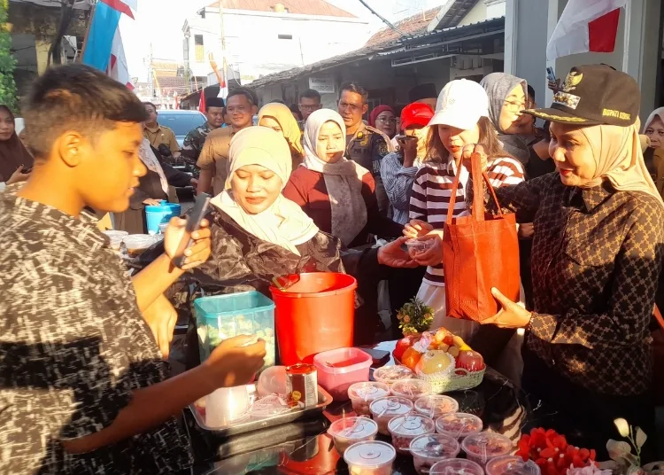 Bupati Kendal, Dyah Kartika Permanasari (kanan), berbagi makanan di tradisi weh-wehan Kaliwungu beberapa waktu lalu. (Anik Kustiani/Lingkarjateng.id)
