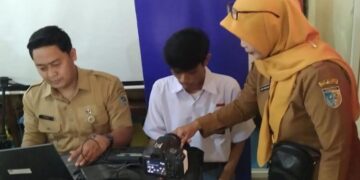 Dindukcapil Demak Sasar 42 Sekolah Layani Siswa Bikin KTP dan Adminduk Lainnya 10 Petugas Dinas Kependudukan dan Pencatatan Sipil (Dindukcapil) Kabupaten Demak mendampingi siswa rekam data pembuatan KTP. (Burhanuddin Aslam/Lingkarjateng.id)