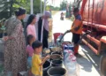 Petugas BPBD saat menyalurkan bantuan air bersih di Desa Sambung, Gajah, Demak. Foto: Burhan/Lingkar