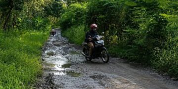 Pemerintah Pusat Tetapkan DAK 2026 Rp2,3 T, Blora Harap Masuk Daftar Prioritas Penerima 10 ILUSTRASI: Seorang pengendara motor melintas di jalan rusak wilayah Kabupaten Blora. (Eko Wicaksono/Lingkarjateng.id)