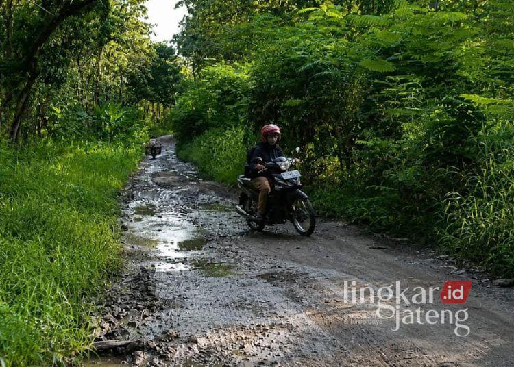 ILUSTRASI: Seorang pengendara motor melintas di jalan rusak wilayah Kabupaten Blora. (Eko Wicaksono/Lingkarjateng.id)