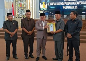 Plt Bupati Pekalongan Sukirman (tengah) menyerahkan dokumen Rancangan Perubahan Kebijakan Umum Anggaran (KUA) dan Perubahan Prioritas dan Plafon Anggaran Sementara (PPAS) Tahun Anggaran 2026 kepada Ketua DPRD Kabupaten Pekalongan Abdul Munir dalam Rapat Paripurna DPRD, Rabu, 5 Agustus 2026. (Fahri Akbar/Lingkarjateng.id)