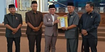 Plt Bupati Pekalongan Sukirman (tengah) menyerahkan dokumen Rancangan Perubahan Kebijakan Umum Anggaran (KUA) dan Perubahan Prioritas dan Plafon Anggaran Sementara (PPAS) Tahun Anggaran 2026 kepada Ketua DPRD Kabupaten Pekalongan Abdul Munir dalam Rapat Paripurna DPRD, Rabu, 5 Agustus 2026. (Fahri Akbar/Lingkarjateng.id)