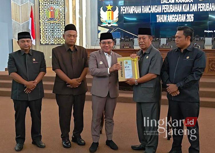 Plt Bupati Pekalongan Sukirman (tengah) menyerahkan dokumen Rancangan Perubahan Kebijakan Umum Anggaran (KUA) dan Perubahan Prioritas dan Plafon Anggaran Sementara (PPAS) Tahun Anggaran 2026 kepada Ketua DPRD Kabupaten Pekalongan Abdul Munir dalam Rapat Paripurna DPRD, Rabu, 5 Agustus 2026. (Fahri Akbar/Lingkarjateng.id)