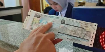 ILUSTRASI: Seorang wajib pajak menunjukkan dokumen pembayaran pajak kendaraan. (Fahri Akbar/Lingkarjateng.id)