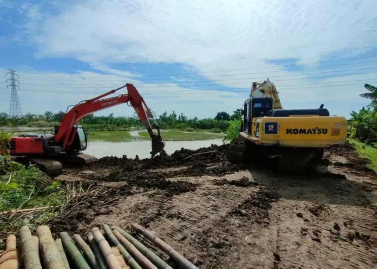 Sebuah alat berat diterjunkan untuk melakukan normalisasi sungai. Foto : Lingkar Network/Burhan