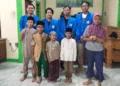 Bastian (dua dari kiri) bersama rekan satu timnya berfoto bersama anak-anak difabel. Foto : Lingkar Network/Burhan