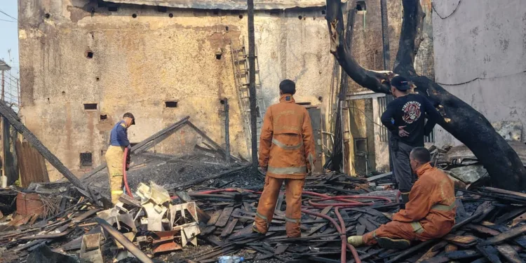Petugas Damkar melakukan pemadaman dan pendinginan gudang penyimpanan material kayu yang terbakar di Gang Patung, Desa Gembong, Kecamatan Kedungwuni, Kabupaten Pekalongan, Senin (21/9/2026). Foto : Fahri Akbar / Lingkar