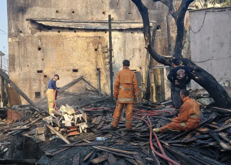 Petugas Damkar melakukan pemadaman dan pendinginan gudang penyimpanan material kayu yang terbakar di Gang Patung, Desa Gembong, Kecamatan Kedungwuni, Kabupaten Pekalongan, Senin (21/9/2026). Foto : Fahri Akbar / Lingkar