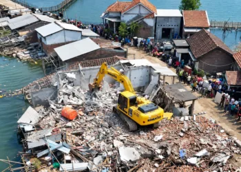 Ekskavator membongkar bangunan liar di bantaran Sungai Tuntang Lama, Kecamatan Bonang, Kabupaten Demak. (M. Burhanuddin Aslam/Lingkarjateng.id)