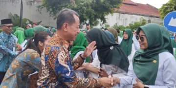 Bupati Kudus, Sam'ani Intakoris, berjabat tangan dengan Pegawai Pemerintah dengan Perjanjian Kerja (PPPK) Paruh Waktu di Halaman Pendopo Kabupaten Kudus saat pengangkatan tahun 2025 lalu. (Antara/Lingkarjateng.id)