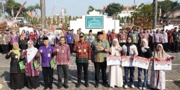 Bupati Jepara, Witiarso Utomo (kelima kiri) didampingi Wakil Bupati M. Ibnu Hajar (kelima kanan) menyerahkan secara simbolis bantuan beasiswa Perguruan Tinggi di Halaman Sekretariat Daerah Jepara pada Selasa, 1 September 2026. (Tomi Budianto/Lingkarjateng.id)