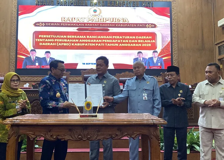 Plt Bupati Pati, Risma Ardhi Chandra, bersama pimpinan DPRD Pati menunjukkan dokumen perubahan APBD 2026 dalam rapat paripurna, Jumat, 18 September 2026. (Fahtur Rohman/Lingkarjateng.id)